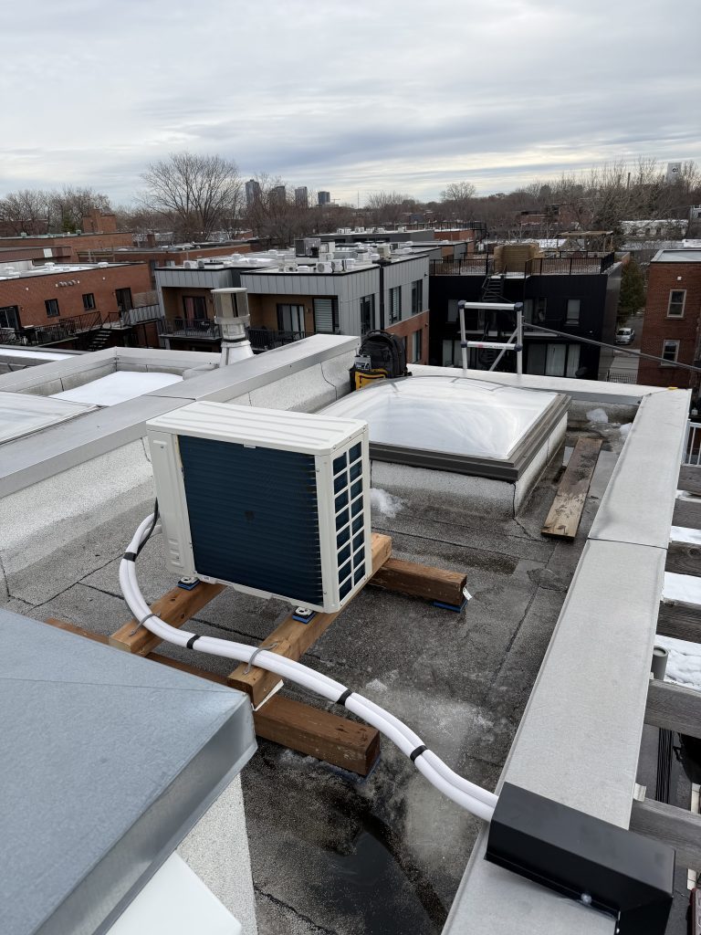 Unité extérieure de thermopompe installée sur le toit d’un plex de Pointe-Saint-Charles